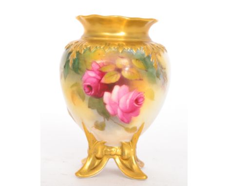 A Royal Worcester decorated by Millie Hunt, the egg shaped vase raised to four spray feet decorated with crimson and pink ros