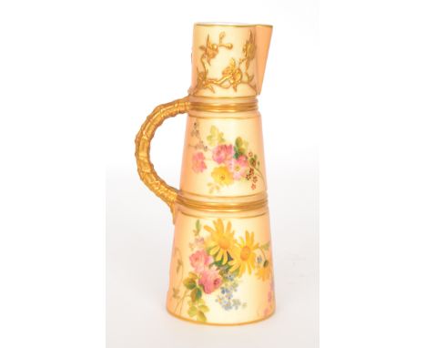 An early 20th Century Royal Worcester blush ivory ewer, decorated with flowers and gilded bands, the handle formed as natural