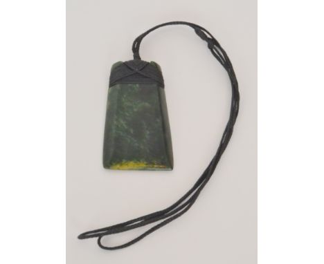 A 20th Century Maori jade or pounami Hei Toki pendant, the dark green adze blade pendant of rectangular outline with chamfere