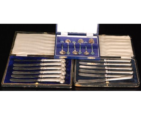 A cased set of six tea spoons each with green and white enamel detail to stem and blue and yellow flower to terminal, Birming