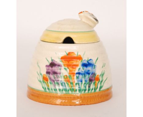 A Clarice Cliff beehive honey pot circa 1930 hand painted in the Crocus pattern with sprays of flowers with yellow, green and