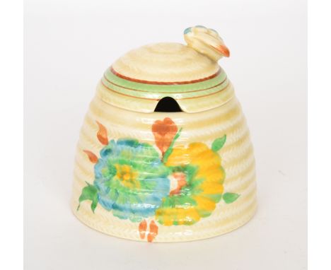 A Clarice Cliff beehive honey pot in the Honeydew pattern, hand painted with two stylised flower heads below green and brown 