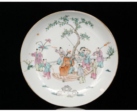 A 19th Century Chinese shallow bowl decorated with enamel painted scenes of figures in a landscape setting and standing upon 