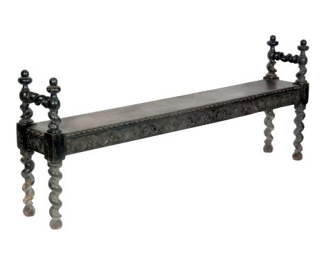 A late 19th to early 20th Century oak bench or window seat with a foliate carved frieze and with barleytwist supports, some w