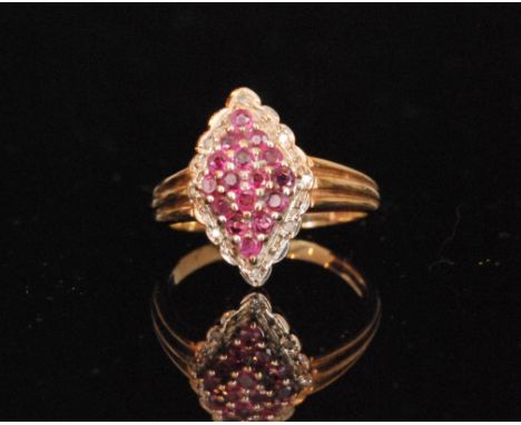 A 9ct hallmarked ruby and diamond marquise shaped cluster ring, sixteen central claw set rubies within diamond detailed borde
