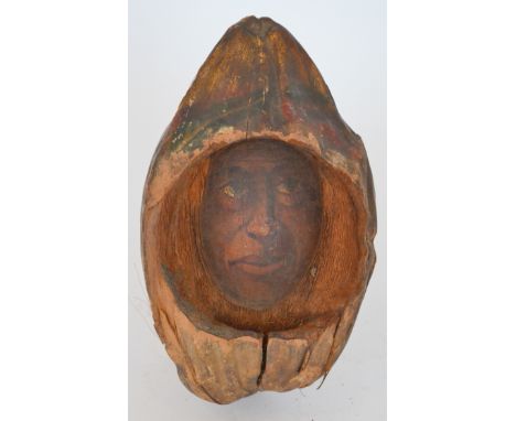 A carved and painted coconut detailed with a portrait of a man, length 33cm. 