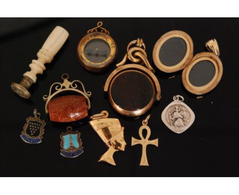A modern 9ct hallmarked locket with applied Celtic knot decoration and collar set ruby, together with two Egyptian pendants, 
