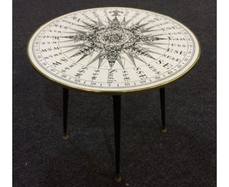 A post-war revolving circular occasional table, after Fornasetti, with printed compass detail and gilt metal rim above four t