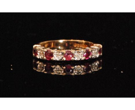 A 9ct hallmarked ruby and diamond half eternity ring, nine alternating illusion and claw set stones, ring size N.