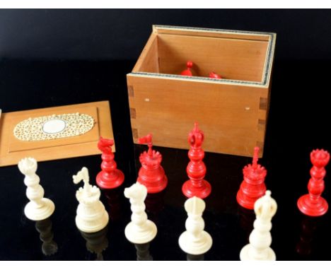 Late 19th/ early 20th century red and white ivory chess set, kings 7cm high, pawns 4cm high, in sandalwood box with ivory dec