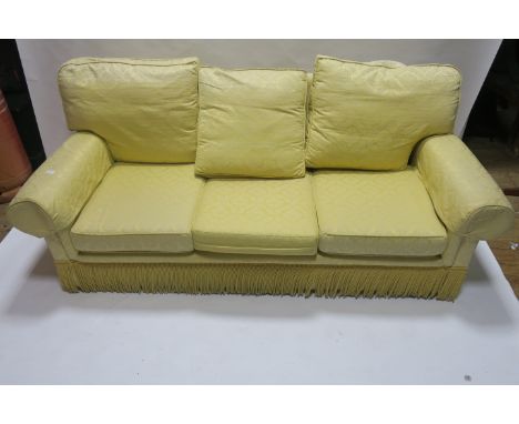 A THREE SEATER SOFA 20th CENTURY the yellow ground decorated with foliate motifs with overstuffed back and sides loose cushio