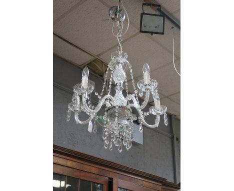 A FIVE ARM CUT GLASS CHANDELIER the scrolled arms with diamond cut drip pans hung with faceted chains and pendant drops 