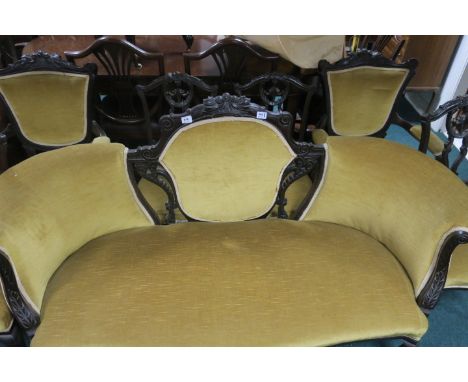 A VICTORIAN MAHOGANY CARVED DRAWING ROOM SUITE comprising of a sofa two carvers and four side chairs finished in gold velvet 