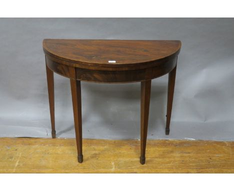 A MAHOGANY AND KINGSWOOD CROSSBANDED FOLDOVER CARD TABLE, 19th CENTURY, of demi-lune outline the hinged top containing a baiz