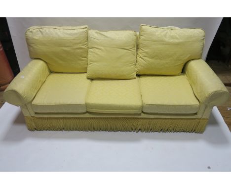 A THREE SEATER SOFA 20th CENTURY the yellow ground decorated with foliate motifs with overstuffed back and sides loose cushio