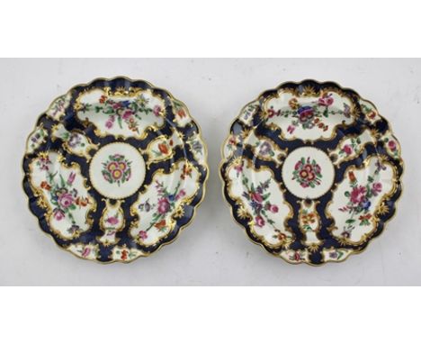 A PAIR OF DR WALL PERIOD WORCESTER PORCELAIN PLATES, blue scale ground with reserves hand painted with flowers, gilt wavy edg