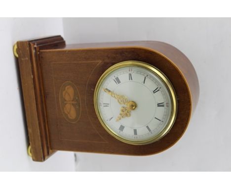 AN EDWARDIAN MAHOGANY CASED MANTEL CLOCK, butterfly panel decoration, circular movement, raised on brass bun feet, 21.5cm hig