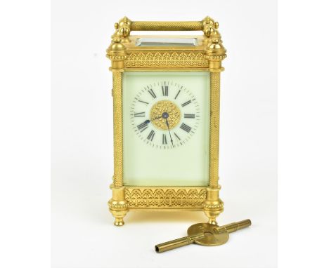 An R &amp; Co French brass cased carriage clock with a white enamel dial having Roman numerals, set in a pierced filigree dec