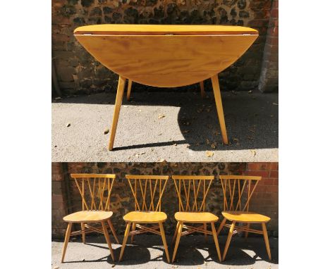 A blonde elm Ercol drop leaf circular dining table, together with six candlestick lattice beech and elm dining chairs, no lab