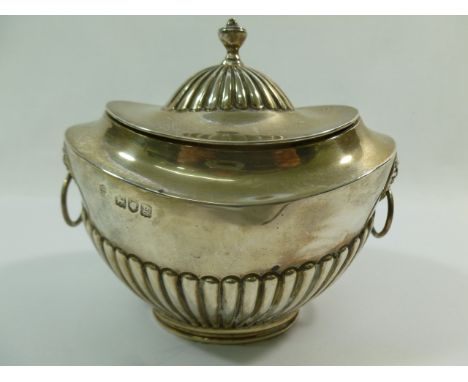 An Edwardian silver tea caddy, of classical form with half reeded body and lion mask ring handles, London 1902, by Charles St