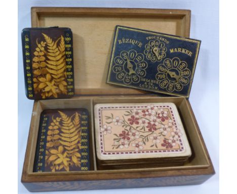 A fernware bezique box, containing two fernware peg boards, a De La Rue & Co. score board and a pack of Goodall and Son playi