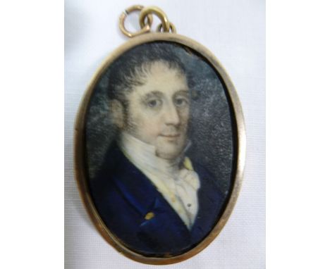 A small 19th century oval portrait miniature on ivory of a man, 3.8cm x 2.5cm, housed in a gold locket mount with an agate se