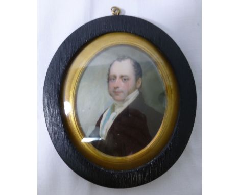 A 19th century oval portrait miniature of a gentleman, wearing a black coat, on the card to the reverse of the miniature the 