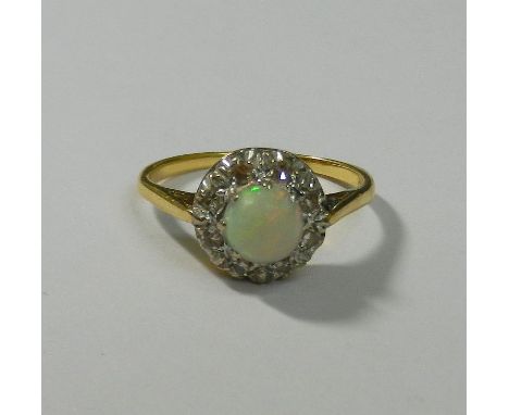 An 18 carat gold and platinum opal and diamond circular cluster ring,  the eight eight-cut diamond surround in illusion setti