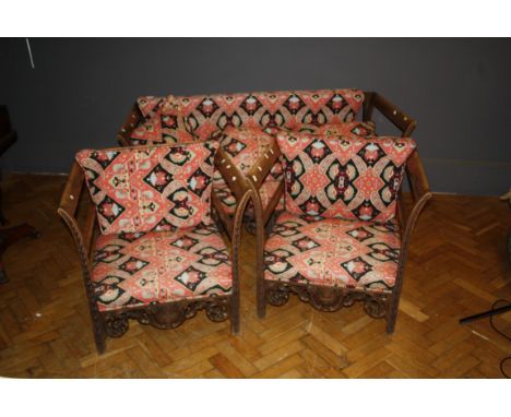 An early 20th century Spanish walnut three piece lounge suite, with open flared sides and carved supports, 168cm wide the sof