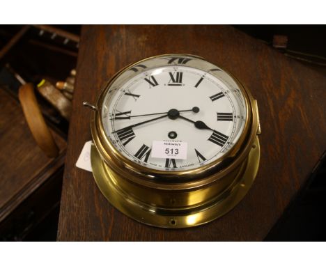 An early 20th century Smith's brass ship's clock of traditional cylindrical form with hinged bevelled glass enclosing an enam