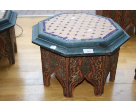 An Eastern octagonal low table, with tile worked top and painted and arcaded sides, 44cm wide