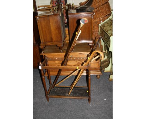 A 1920s oak two section hall stick stand, with a collection of walking and thumbsticks some inset with ornate fishing flies