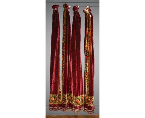 A set of four lined heavy velvet curtains, each pane bordered with a golden band of flowers on a wine ground, 112cm wide x 24