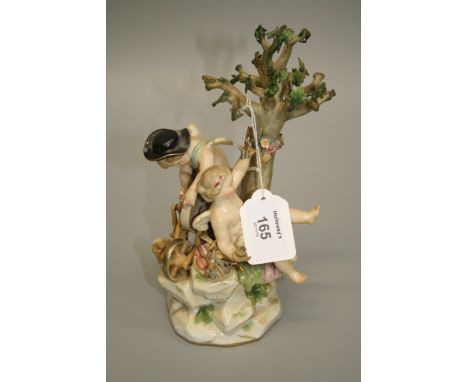 A 19th century Meissen porcelain figure group of young boy and girl cupids, he sits with hat at a grinding wheel sharpening a