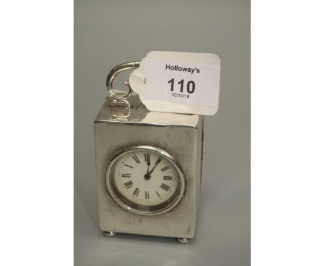 A small silver mounted carriage clock, the engine-turned case with hinged carrying handle, on four ball feet, white enamel di