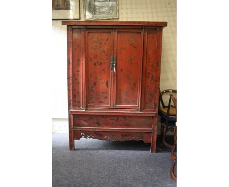 An antique timber constructed Chinese wedding cupboard, red lacquer painted with gilded chinoiserie detail, the rectangular t