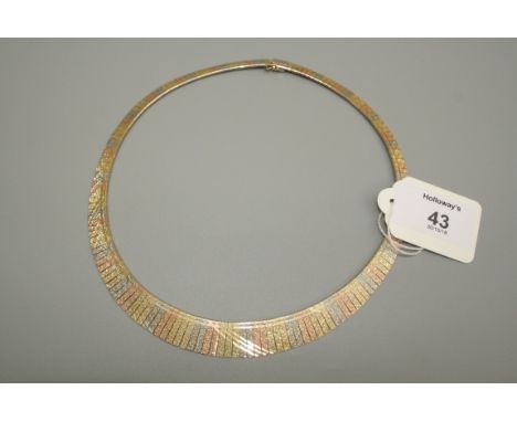 A fringe necklace, the graduated tri-coloured textured links with polished bands, push button clasp, marked '14', 42cm length