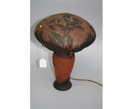 An Emile Gallé-style cameo glass table lamp and shade, decorated with flowers and foliage against a mottled orange ground, 38