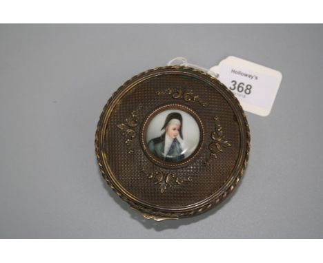A cylindrical brass box, the hinged cover set with an enamel plaque of a young Napoleon, 9cm diameter