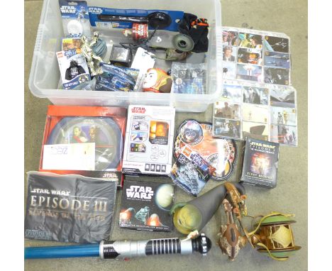 A collection of Star Wars items including a T-shirt, watch, Lego, audio cassettes, collectors cards, toys, figures, light sab