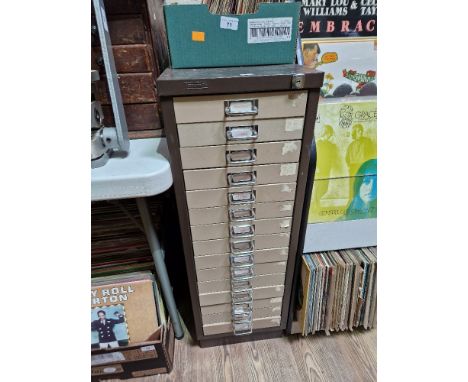 A 15 drawer triumph metal cabinet and contents comprising of clock making spares.