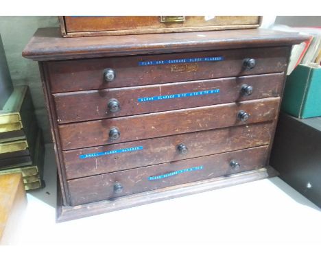 A horologist's five drawer chest and contents comprising watch and clock making spares.