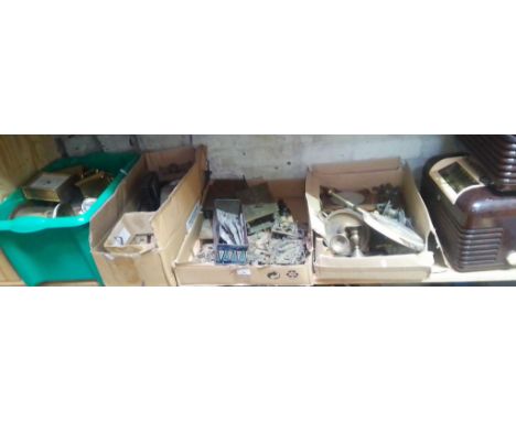 A quantity of clock spares and two bakelite radios. 