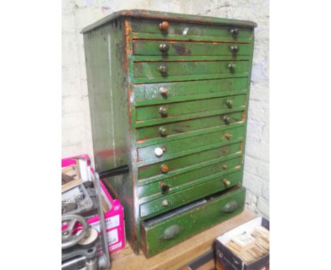 A large green horologist's chest and contents comprising watch and clock making spares.