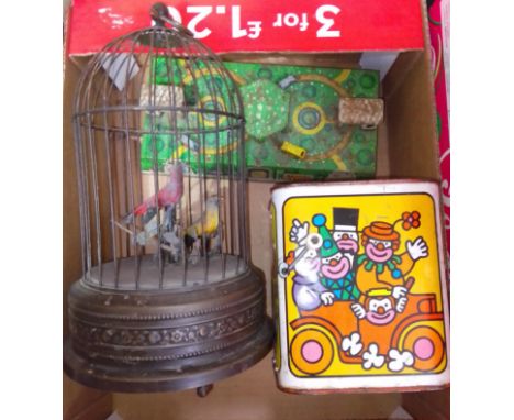 Three vintage toys comprising a singing bird automaton, a jack in the box and a town with wind up moving vehicles.