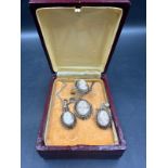A three piece Cameo set, ring, earrings and a necklace.