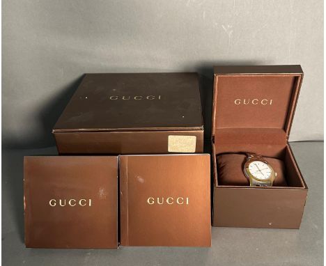 A Gucci watch in original box with manual but watch is missing its back.