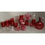 A selection of cranberry Art glass to include jugs, glasses and a bell