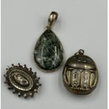 Three silver items of jewellery to include a scarab and a pendant.