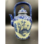 A blue and white Chinese ironstone kettle in the willow pattern
